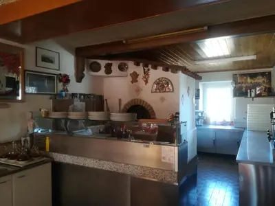 a kitchen with a stove top oven in a room at Hotel Roen Ruffrè-Mendola in Mendola