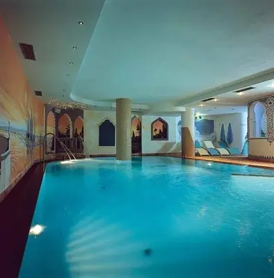 a hotel room with a large bed in a room at Hotel Alba Wellness & Spa in Canazei