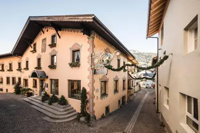 an old building with christmas decorations on a street at Hotel Cavallino D'Oro Bed&Breakfast in Castelrotto