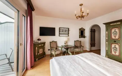 a bedroom with a bed and a table and chairs at Hotel Cavallino D'Oro Bed&Breakfast in Castelrotto