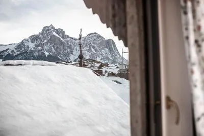 a view of a snow covered mountain from a window at Hotel Cavallino D'Oro Bed&Breakfast in Castelrotto