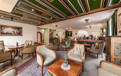 a lobby with chairs and tables and a bar at Hotel Cavallino D'Oro Bed&Breakfast in Castelrotto