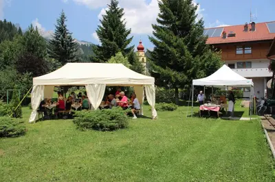 a group of people sitting under a tent in a field at Hotel Rosalpina in Soraga
