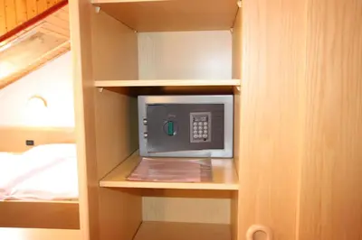 a small microwave in a cabinet in a bedroom at Hotel Rosalpina in Soraga