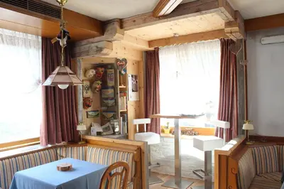 a dining room with a blue table and chairs at Hotel Rosalpina in Soraga
