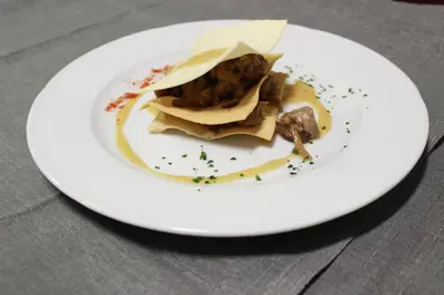 a white plate with food on a table at Hotel Rosalpina in Soraga