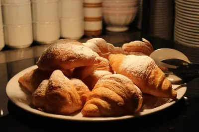 a plate of croissants and other pastries on a table at Hotel Rosalpina in Soraga
