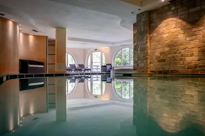 a room with a pool in the middle of a building at Hotel Fanes Suite & Spa in Moena