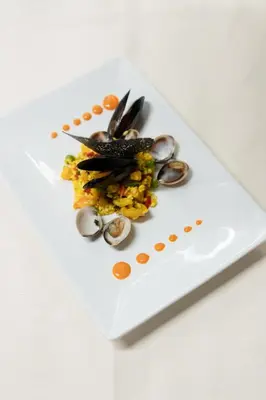 a plate of food with mussels on a white plate at Hotel Fanes Suite & Spa in Moena