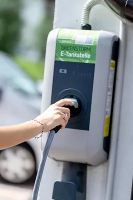a woman is filling a gas pump with a hose at Hotel Fanes Suite & Spa in Moena