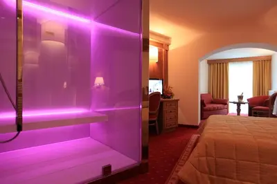 a room with a purple room with a bed at Hotel Fanes Suite & Spa in Moena