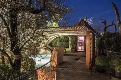 a wooden archway leading to a patio at night at SPA & Relax Hotel Erika in Tirolo