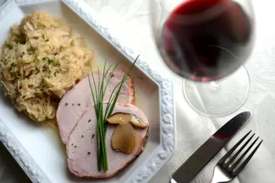 a plate of food with meat and rice and a glass of wine at Cimon Dolomites Hotel in Predazzo