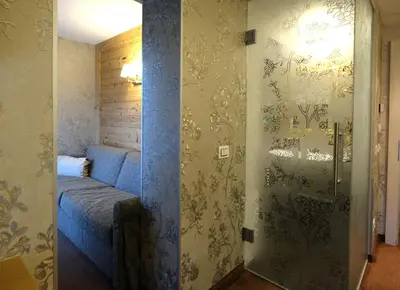 a small room with a blue bed in a room at Cimon Dolomites Hotel in Predazzo