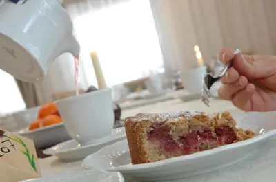 a person eating a piece of cake on a plate at Cimon Dolomites Hotel in Predazzo