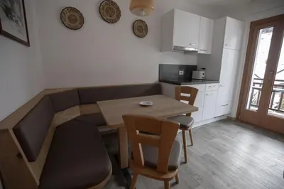 a kitchen with a table and a table and chairs at Villa Ula Verda- Apartments Marianna in Santa Cristina in Val Gardena