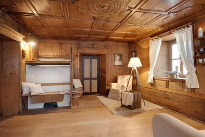 a living room with wooden walls and a wooden ceiling at Chaletapartement Ambiente Villa Mozart mit Sauna in Chienes