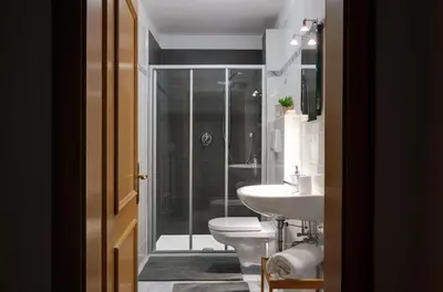 a bathroom with a shower and a toilet and a sink at Chaletapartement Ambiente Villa Mozart mit Sauna in Chienes