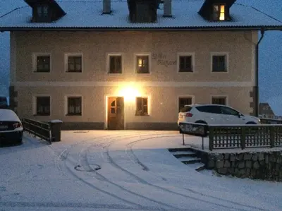 a building with cars parked in front of it in the snow at Chaletapartement Ambiente Villa Mozart mit Sauna in Chienes