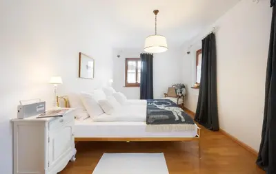 a white bedroom with a bed and a desk at Chaletapartement Ambiente Villa Mozart mit Sauna in Chienes