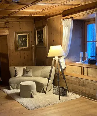 a living room with a couch and a lamp at Chaletapartement Ambiente Villa Mozart mit Sauna in Chienes