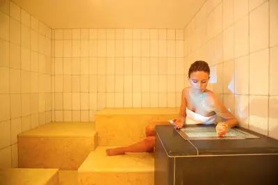 a woman sitting in a bath tub in a bath room at Hotel Blitzburg in Brunico