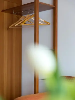 a closet with a wooden shelf and a light at Hotel Blitzburg in Brunico
