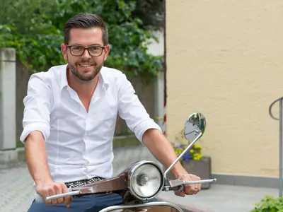 a man is sitting on a scooter at Hotel Blitzburg in Brunico