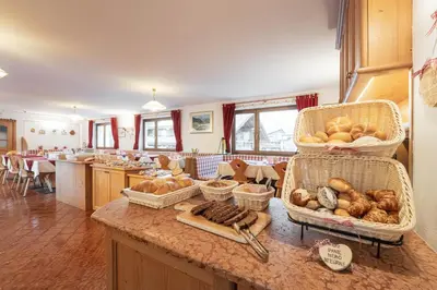 a kitchen with a counter with baskets of bread at Villa Adria B&B in Canazei
