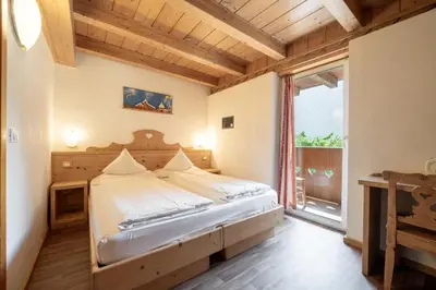 a bedroom with a bed and a large window at Villa Adria B&B in Canazei