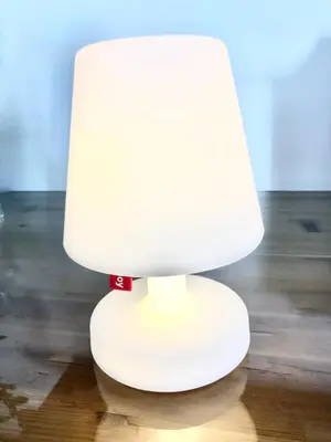 a white lamp sitting on top of a wooden floor at Life Apartment & City Bike in Bolzano