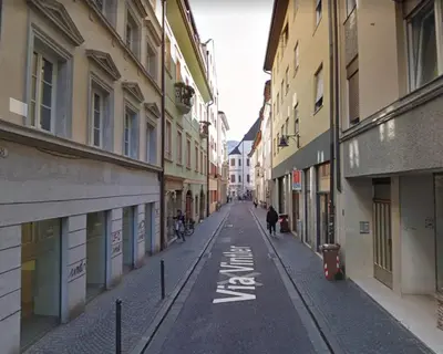 an empty street in a city with buildings at Life Apartment & City Bike in Bolzano