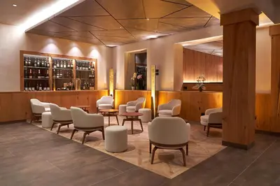 a waiting room with chairs and a bar at Resort Dolce Casa - Family & Spa Hotel in Moena