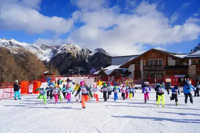 a group of children are skiing in the snow at Resort Dolce Casa - Family & Spa Hotel in Moena