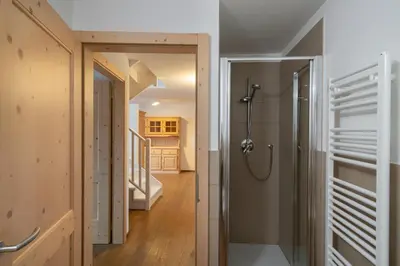a bathroom with a shower and a walk in closet at Casa Chatrian in Moena
