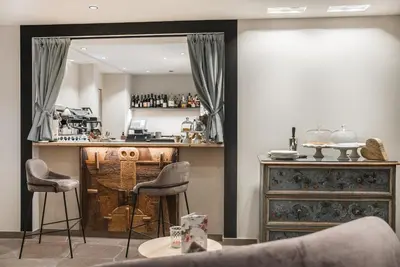 a bar in a room with two stools and a mirror at La Cort My Dollhouse - Adults Only in Ortisei