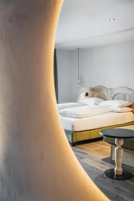 a bedroom with a bed and a table in a room at La Cort My Dollhouse - Adults Only in Ortisei