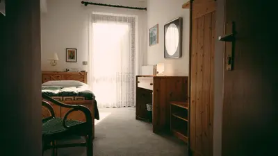 a bedroom with a bed and a window at Sporthotel Europa Sul Lago in Alleghe