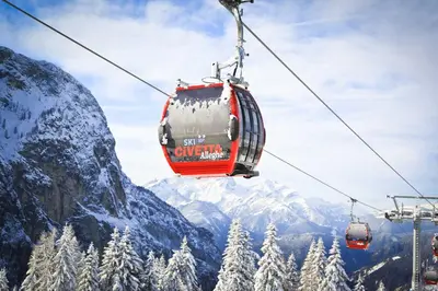 a ski lift in the mountains with snow covered trees at Sporthotel Europa Sul Lago in Alleghe