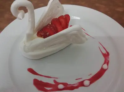a white plate with a dessert with strawberries on it at Park Hotel Miramonti in San Martino di Castrozza