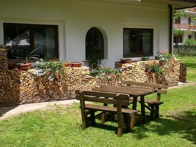 a wooden picnic table and bench in a yard at Park Hotel Miramonti in San Martino di Castrozza