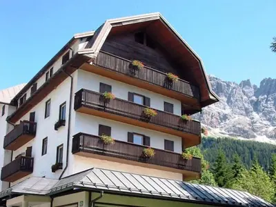 a building with potted plants on the balconies of it at Park Hotel Miramonti in San Martino di Castrozza