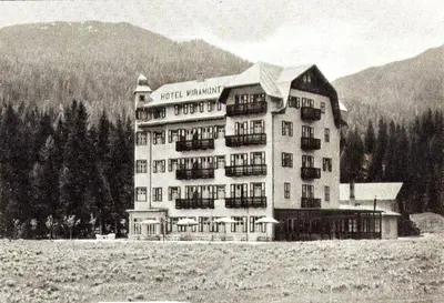a black and white photo of a building in a field at Park Hotel Miramonti in San Martino di Castrozza