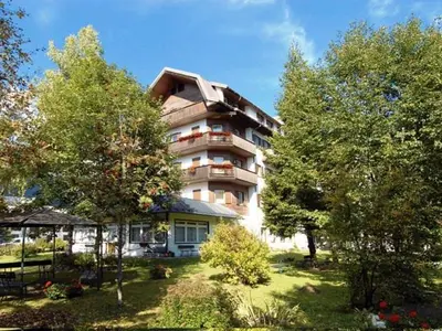 a large apartment building with trees in front of it at Park Hotel Miramonti in San Martino di Castrozza