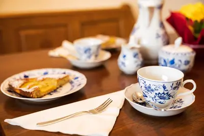 a table with plates of food and cups on it at Trafisolerhof in Vols am Schlern