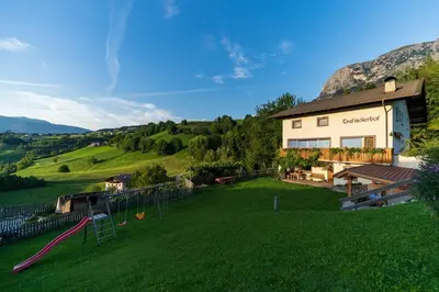a large yard with a playground in front of a building at Trafisolerhof in Vols am Schlern