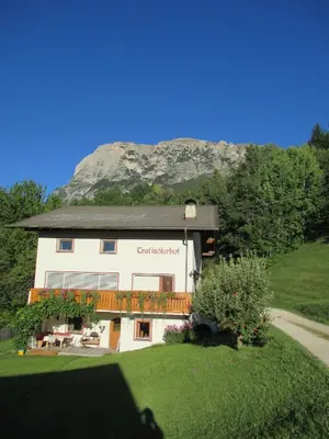 a building with a balcony with a mountain in the background at Trafisolerhof in Vols am Schlern