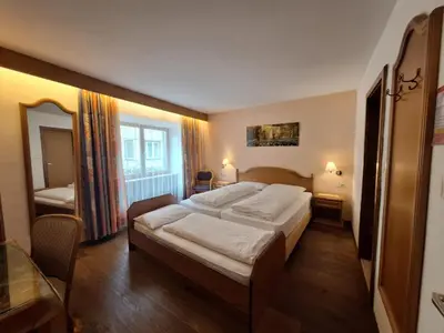 a hotel room with two beds and a mirror at Gasthof Moarwirt in Colle Isarco