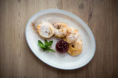 a plate of food with donuts on a table at Gasthof Moarwirt in Colle Isarco