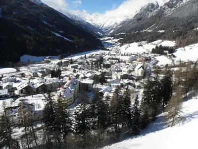 a village covered in snow with mountains in the background at Gasthof Moarwirt in Colle Isarco